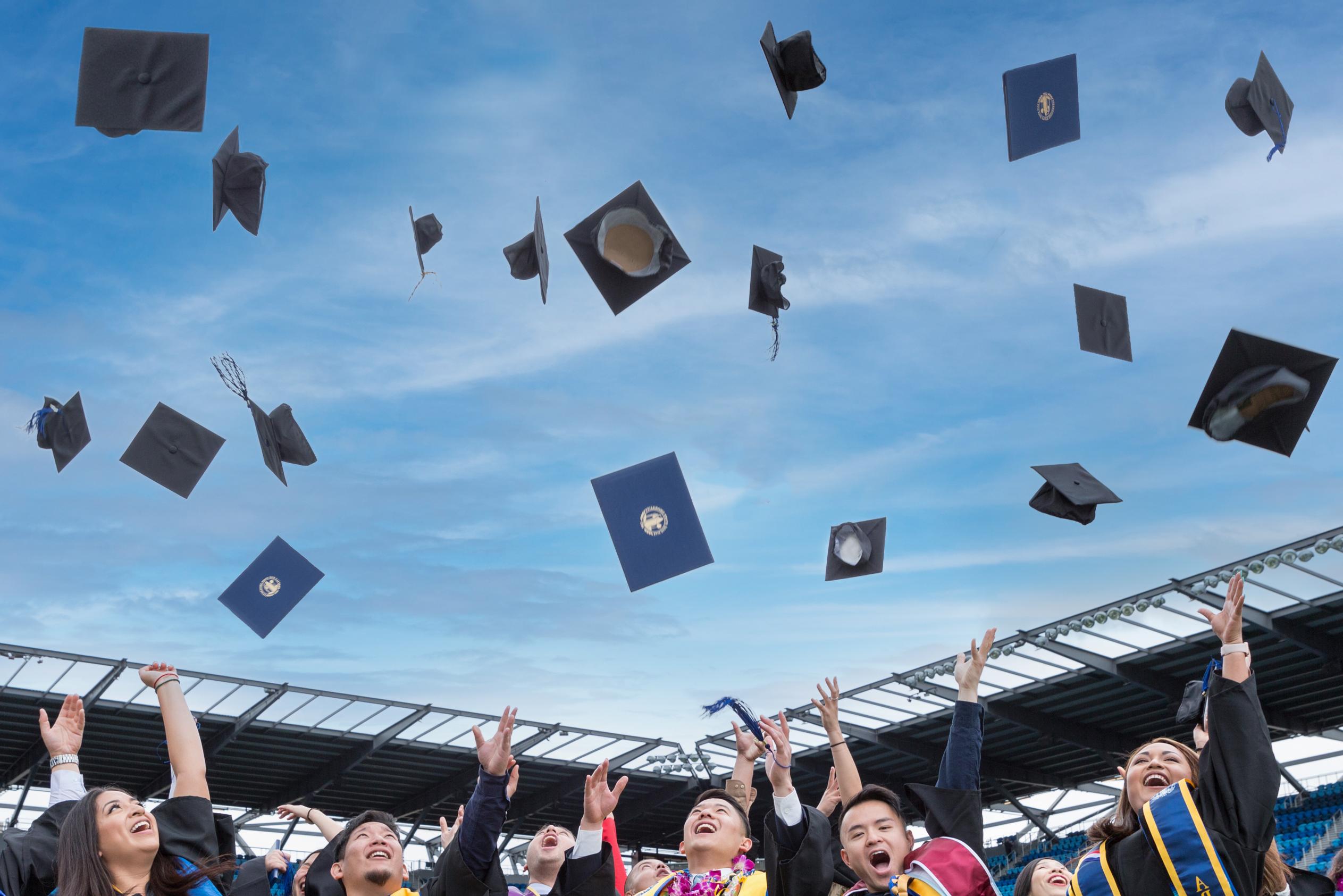 菠菜网lol正规平台 graduates throwing their caps in the air